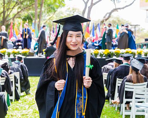 A student returning to her seat after receiving her diploma at graduation.