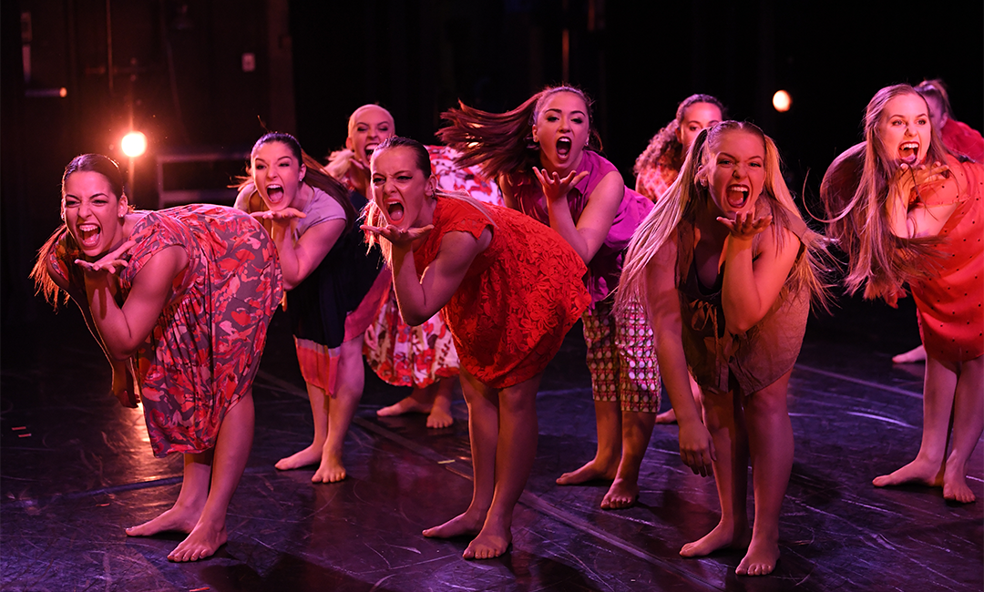 Group of women student dancers on stage engaged in an expressive performance