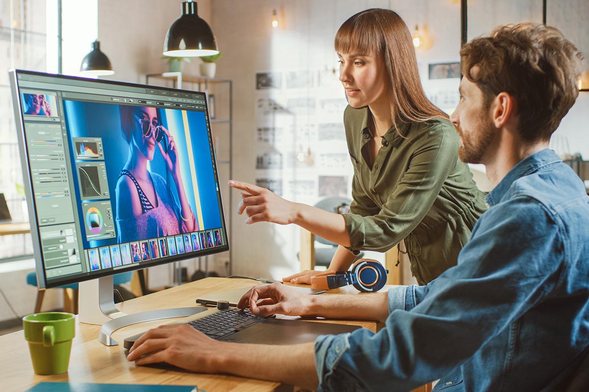 Graphic design student utilizing Adobe graphic design programs on a computer